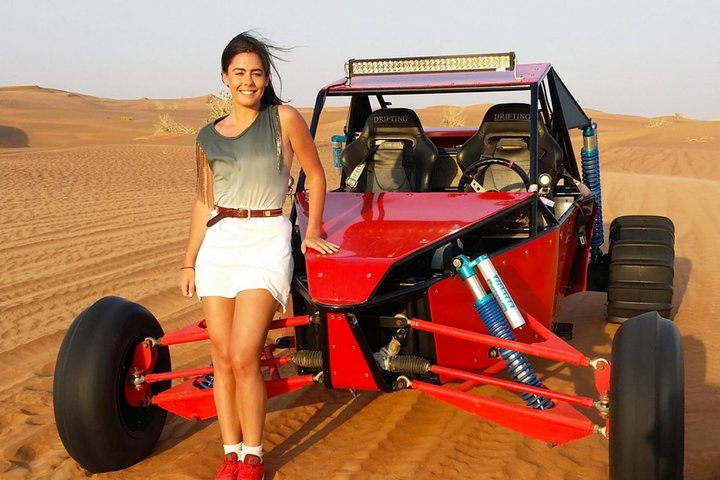 Experience the excitement of self-driving a dune buggy across Dubai's stunning red deserts followed by a scenic camel trek and exhilarating sandboarding amidst breathtaking dunes.